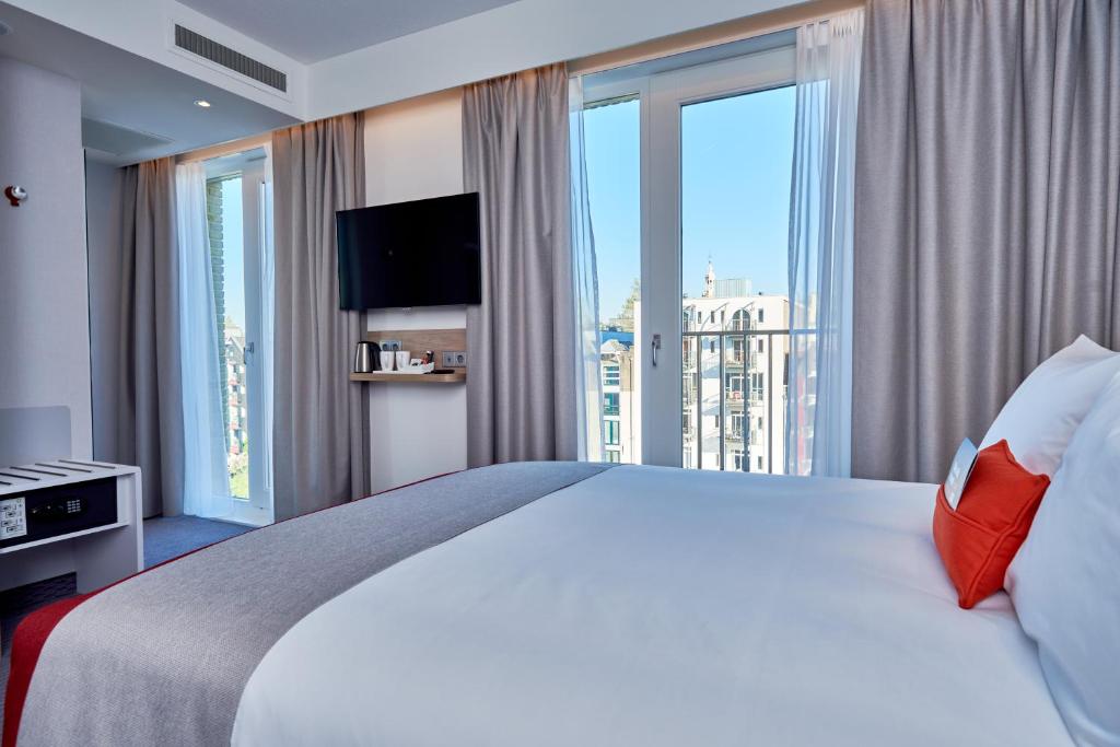 阿姆斯特丹阿姆斯特丹快捷智选假日酒店的酒店客房设有一张大床和大窗户