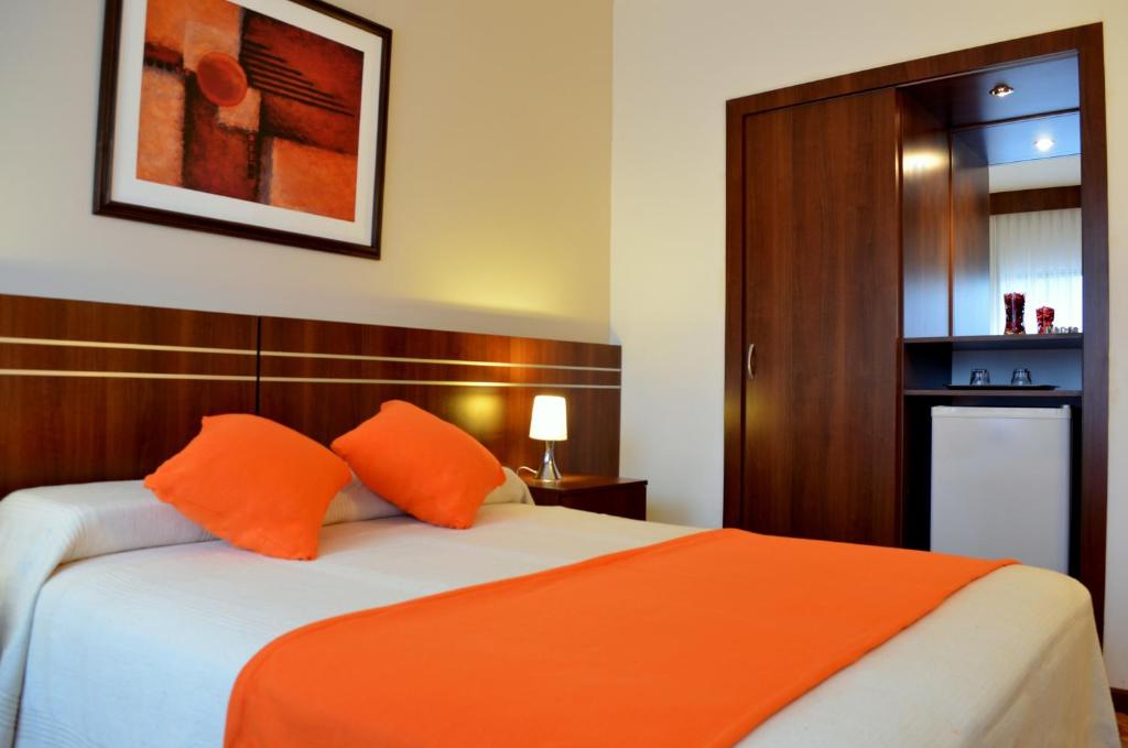 蒙得维的亚美国酒店的一间卧室配有带橙色枕头的床