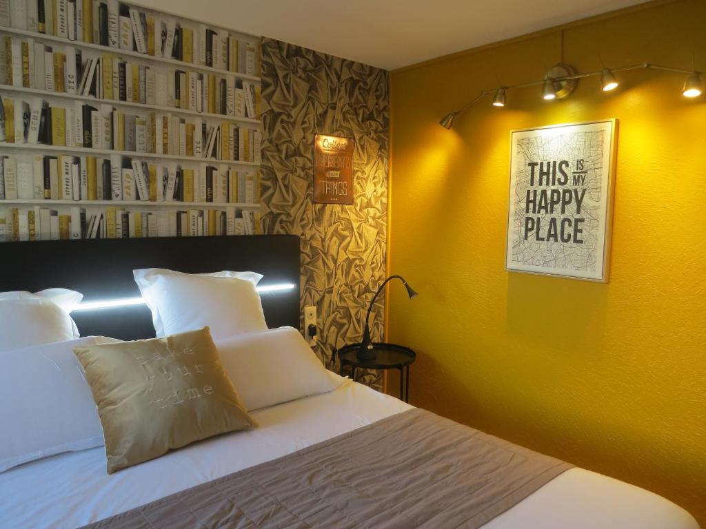 阿维尼翁Hôtel Kyriad Cap Sud的一间卧室配有一张黄色墙壁的床