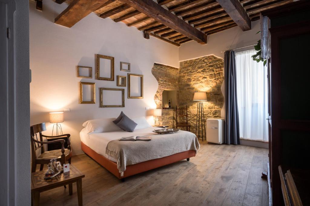 蒙塔尔奇诺Dimora delle Muse的卧室配有一张床和一张桌子及椅子