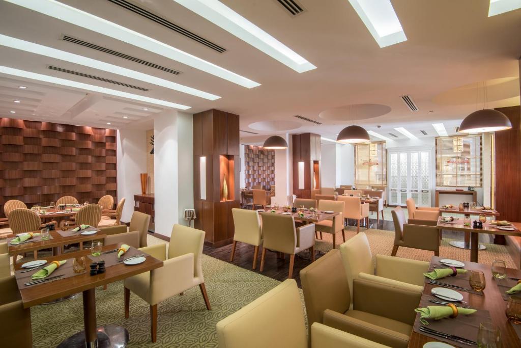 索哈尔索哈尔皇冠假日酒店的一间在房间内配有桌椅的餐厅
