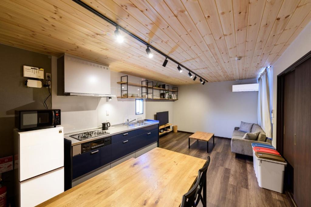 佐世保Rakuten STAY HOUSE x WILL STYLE Sasebo 104的厨房以及带沙发和桌子的客厅。