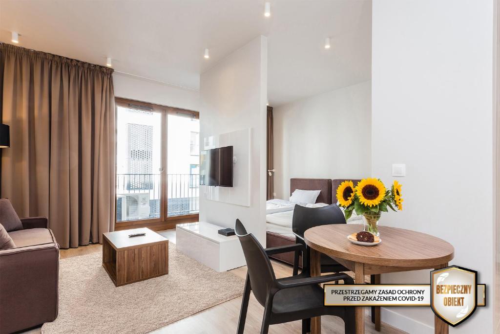 华沙莫克托夫铂金住宅公寓的客厅配有桌子和沙发