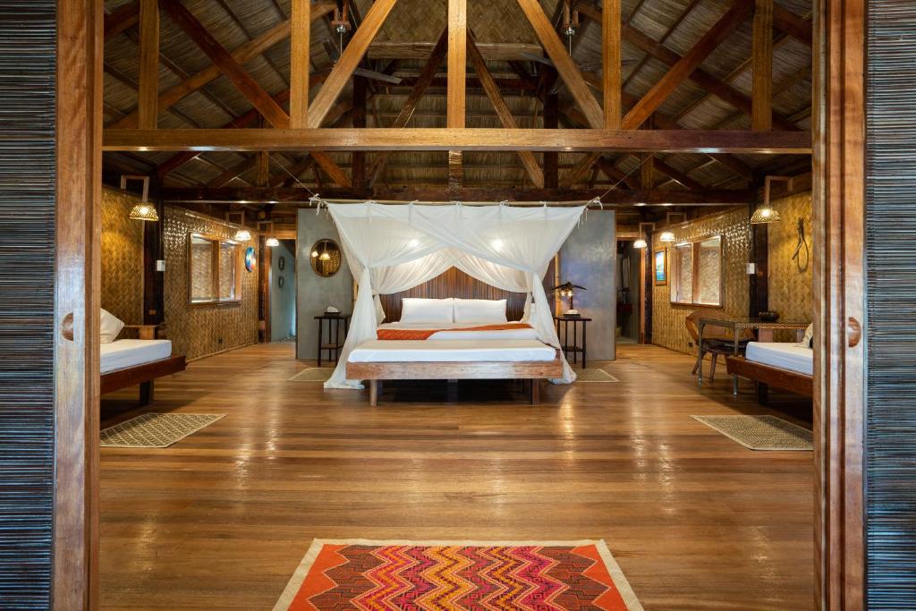 泰泰Flower Island Resort的一间卧室配有一张带蚊帐的床