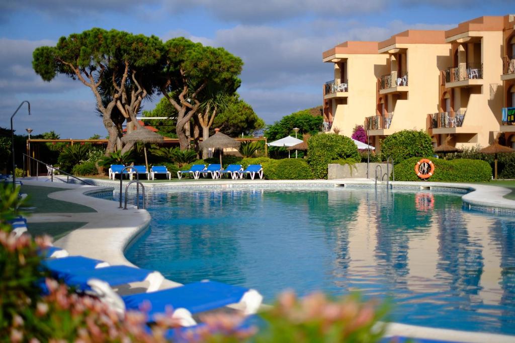 奇克拉纳－德拉弗龙特拉沙丘公寓式酒店的度假村的游泳池,配有蓝色椅子和公寓