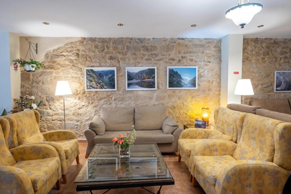 阿尔德亚达维拉德拉里韦拉拉加拉－阿瑞贝斯酒店的带沙发和石墙的客厅