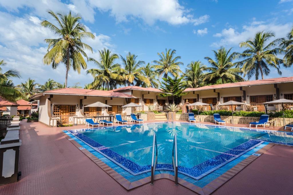 瓦加托利欧尼果度假酒店的享有带椅子和棕榈树的度假村游泳池的景致