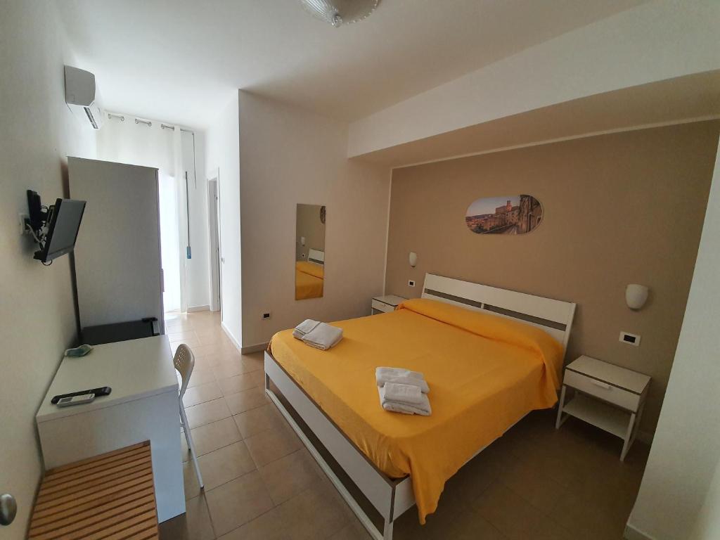 科里利亚诺·卡拉布罗Casale Marcalia - bed & breakfast的一间卧室配有橙色的床和电视