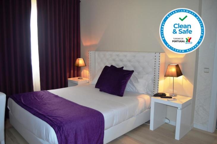 托雷斯诺瓦斯托雷斯诺瓦斯酒店的一间卧室配有一张大床和紫色毯子