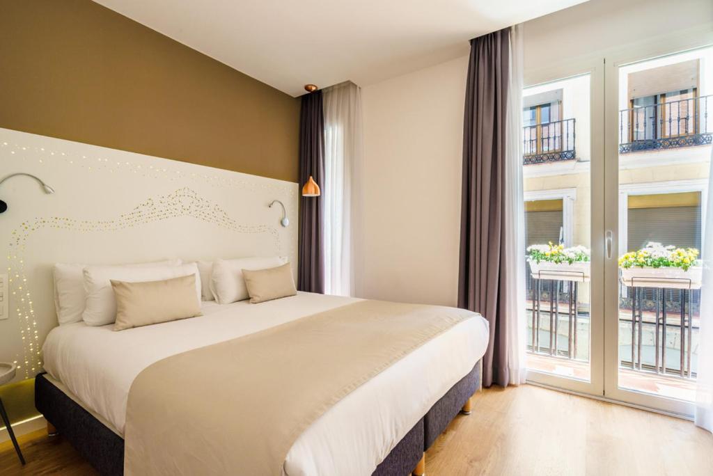 马德里马德里沃尔特旅馆的一间卧室设有一张大床和两个窗户。