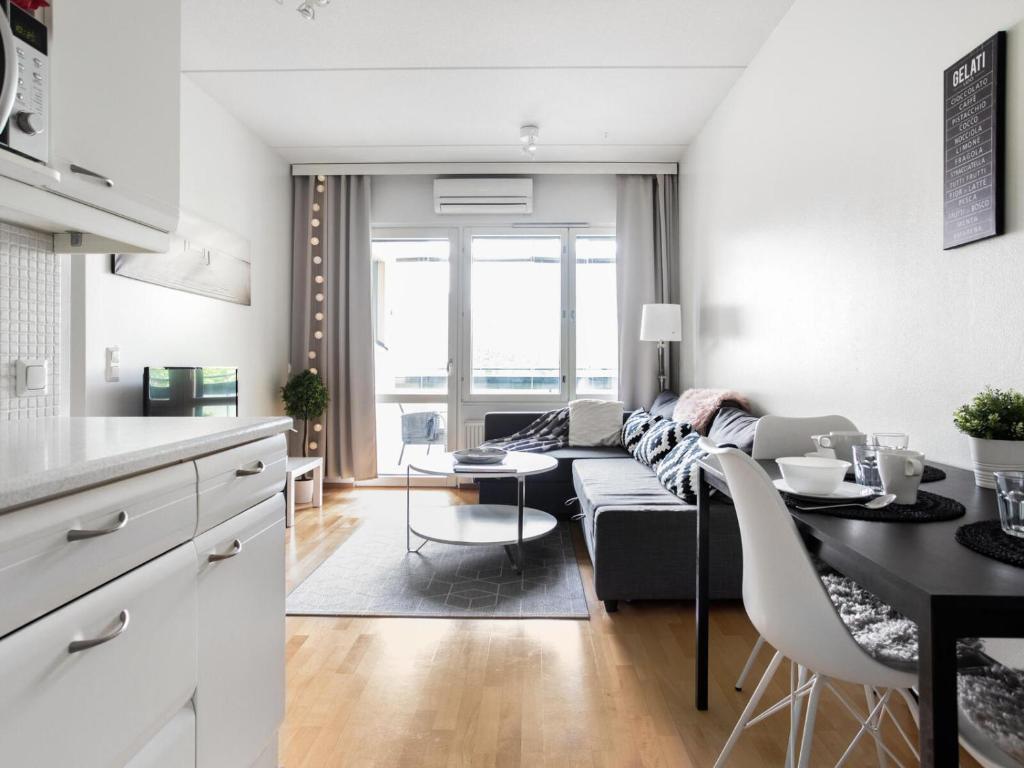 拉赫蒂Kotimaailma Apartments Lahti的厨房以及带沙发和桌子的客厅。