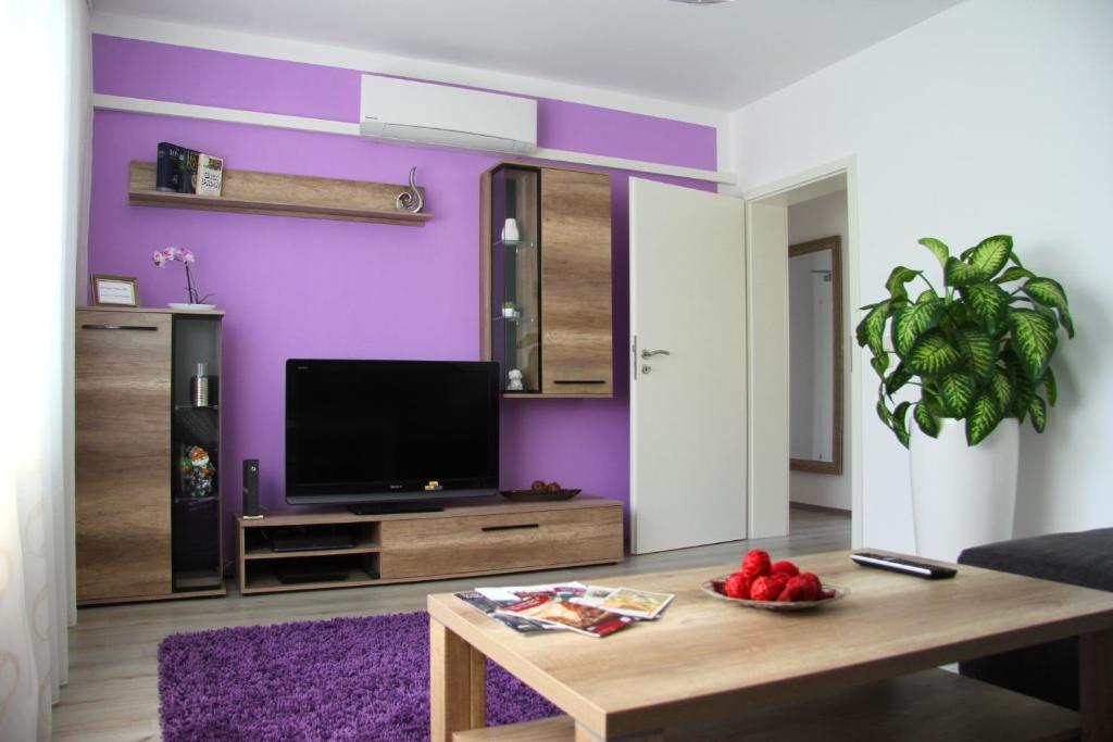特里尔Geräumige 4 Zimmer Wohnung an den Kaiserthermen的客厅设有紫色墙壁和桌子