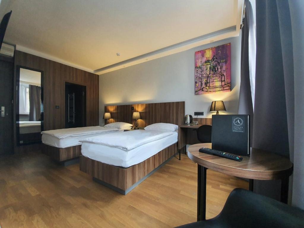 卢布尔雅那阿特里尔酒店的酒店客房设有两张床和一张带电脑的书桌