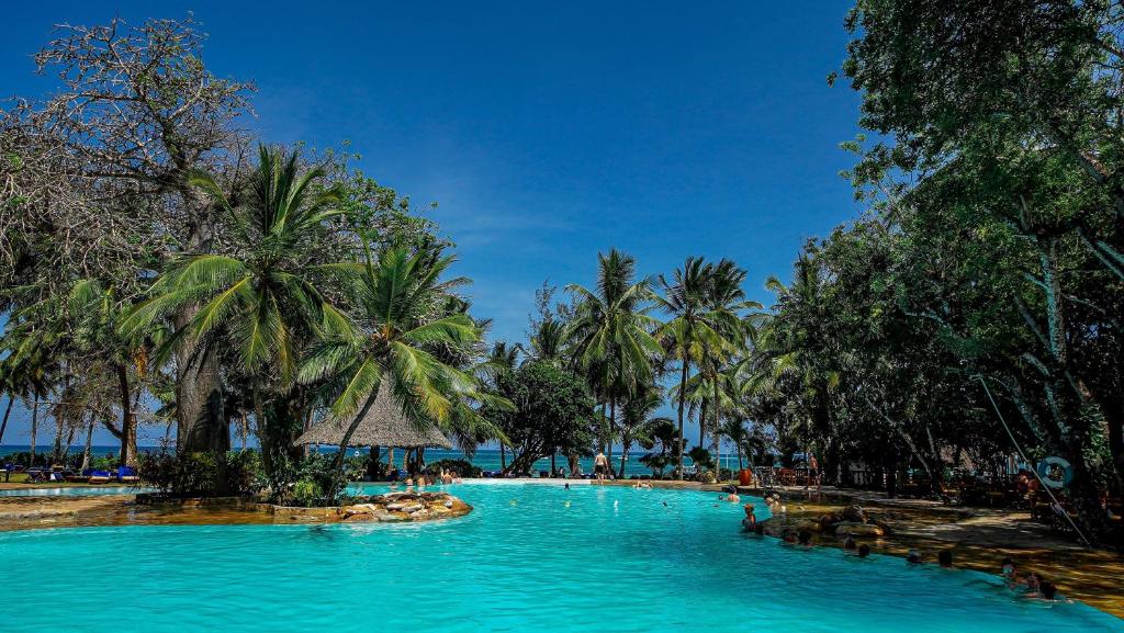 迪亚尼海滩帕皮伦泻湖礁酒店的一座棕榈树和海洋的大型游泳池