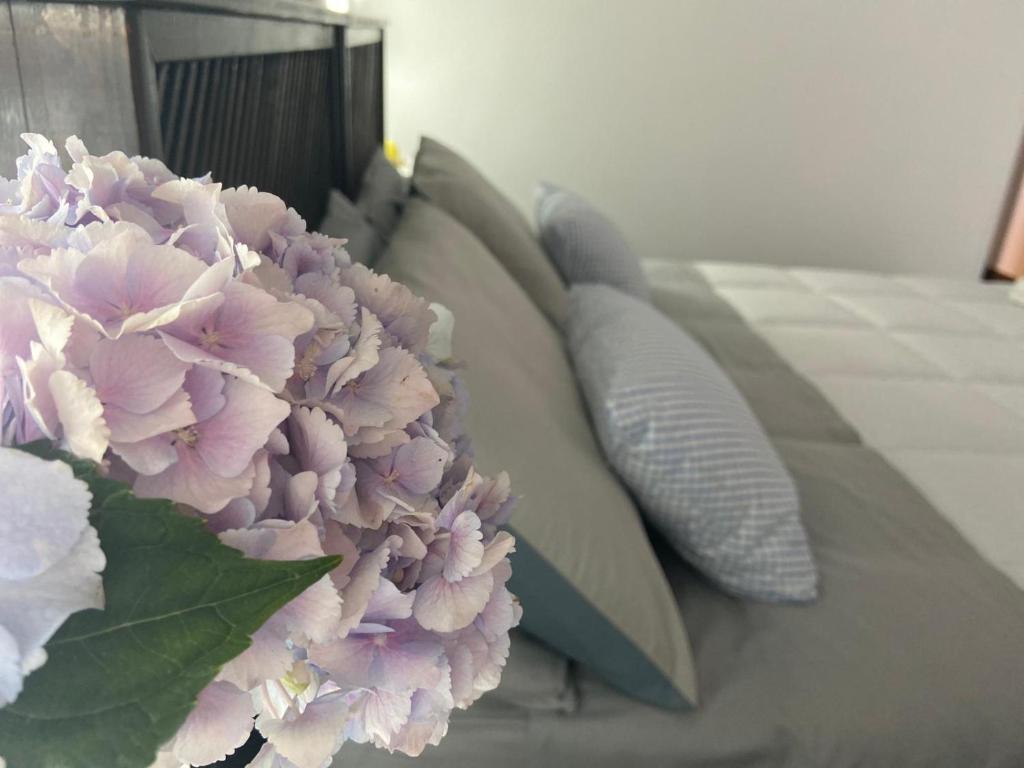 庞贝Gio House Pompei的一张带鲜花的床上的一束枕头