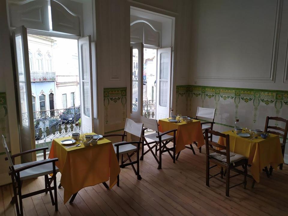 奥良OlhãOmirante Guesthouse的用餐室配有桌椅和黄色桌布