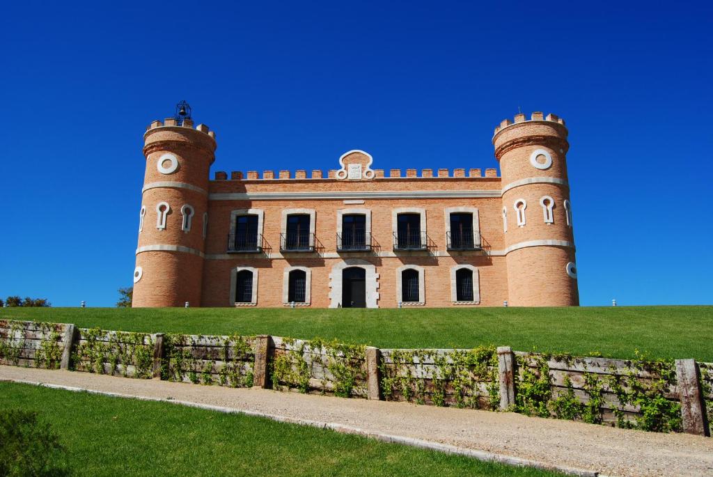 托罗Castillo de Monte la Reina Posada Real & Bodega的山丘上的城堡,前面有围栏