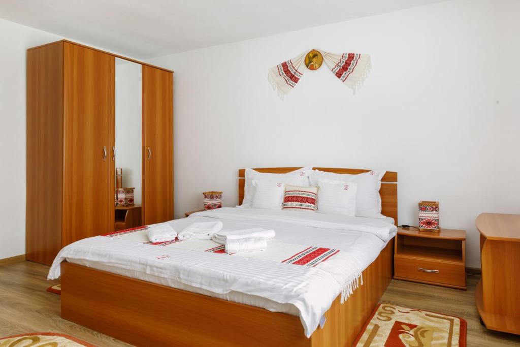 莱斯诺夫Casa Dacică的一间卧室配有一张带白色床单的大床