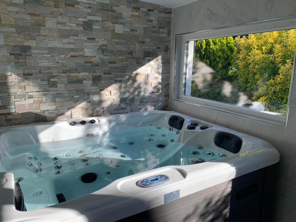 Margny-lès-CompiègneRelax & Spa - Séjour Romantique的一间带大浴缸及窗户的浴室