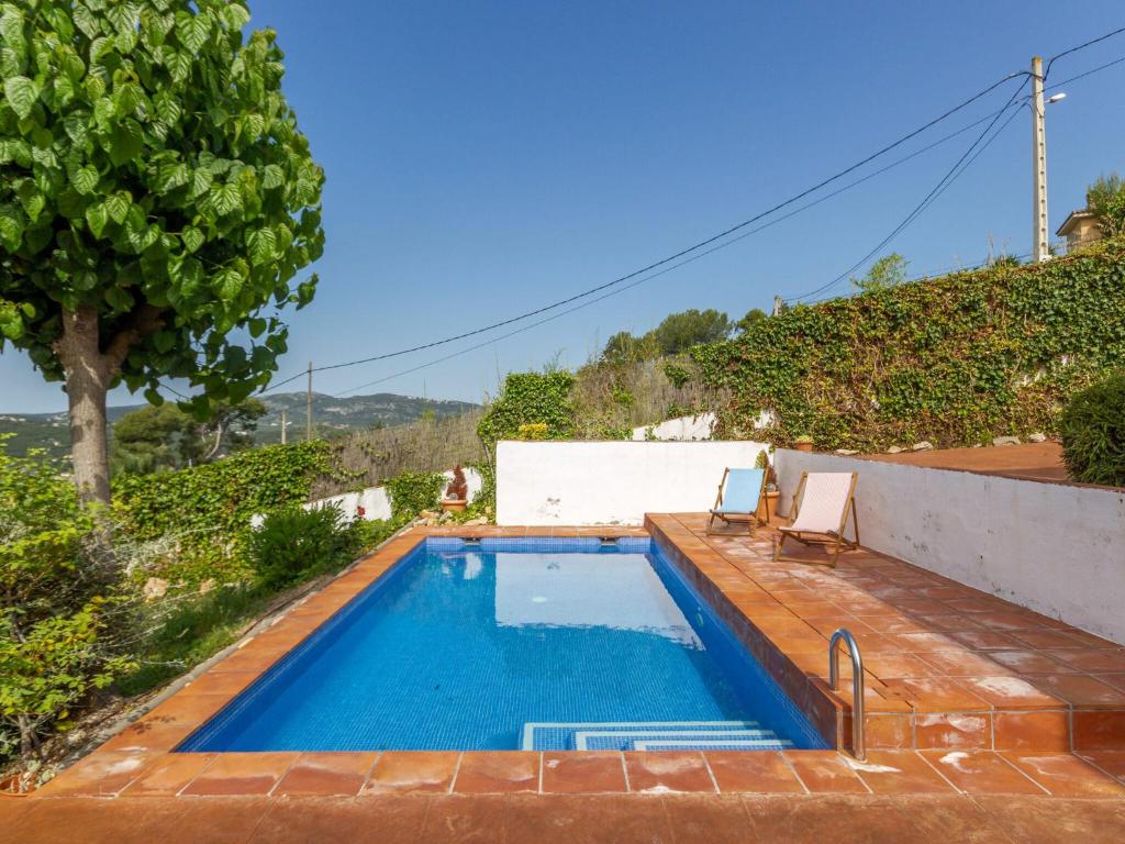 奥利维拉Welcoming Villa in Olivella with Swimming Pool的庭院内一个带长凳和椅子的游泳池