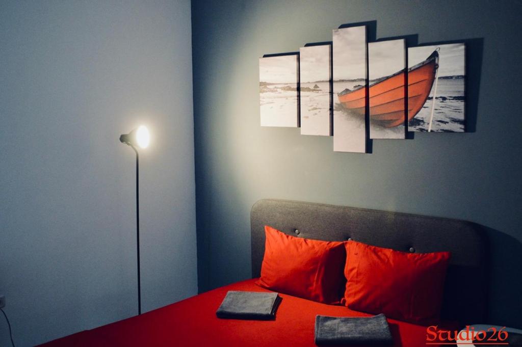 北马马亚-讷沃达里Studio26 Mamaia Nord- Navodari的一间卧室配有带橙色枕头和绘画的床。