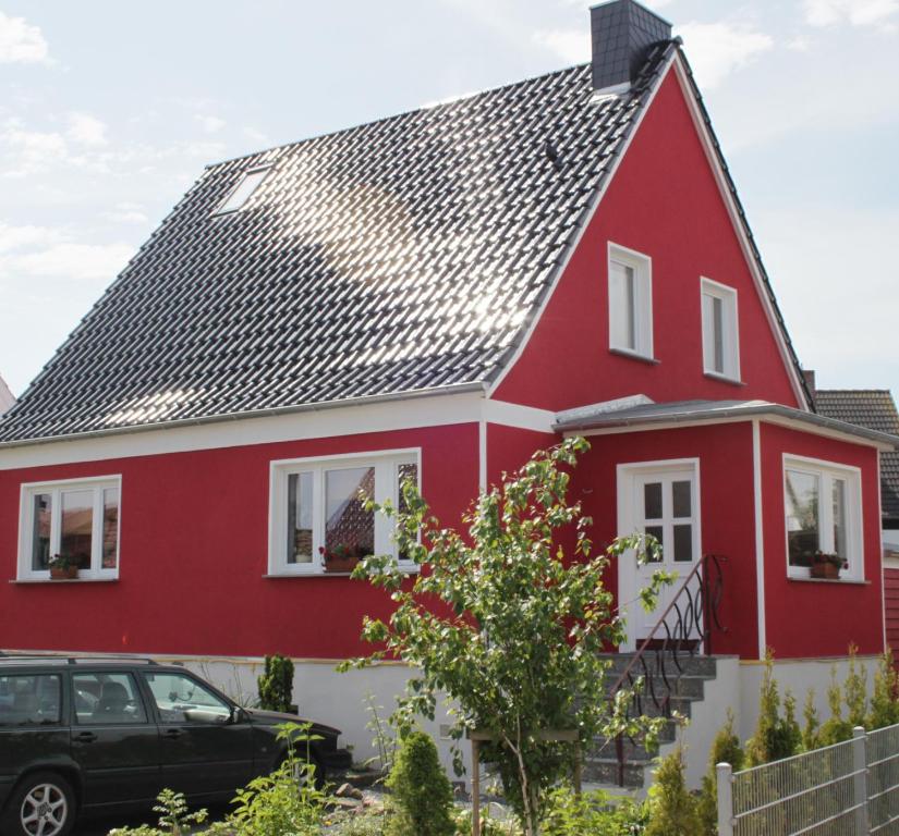 巴特Ostseeurlaub-Barth的黑色屋顶的红白色房子