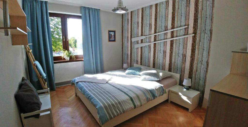 达尔沃沃Gościrada的一间卧室配有一张带蓝色窗帘的床和一扇窗户