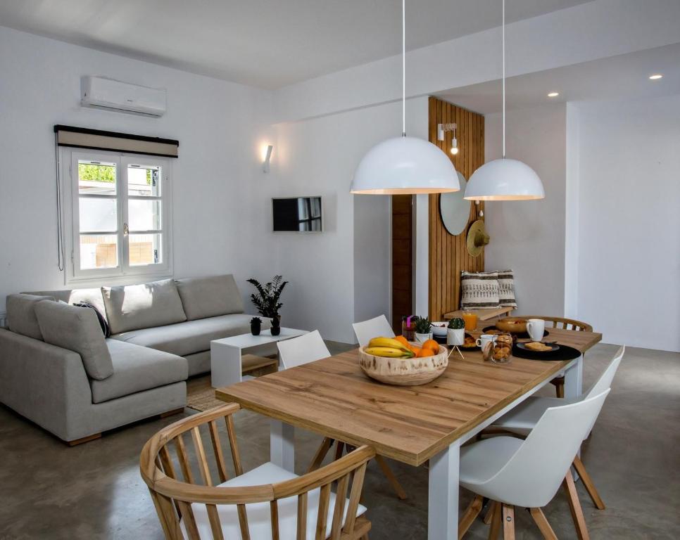 Kalloni Tinoufamily home的厨房以及带木桌和椅子的客厅。