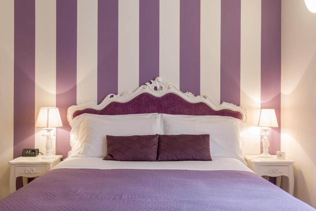 维罗纳Giardino Giusti House & Court的一间卧室配有一张紫色和白色条纹的床