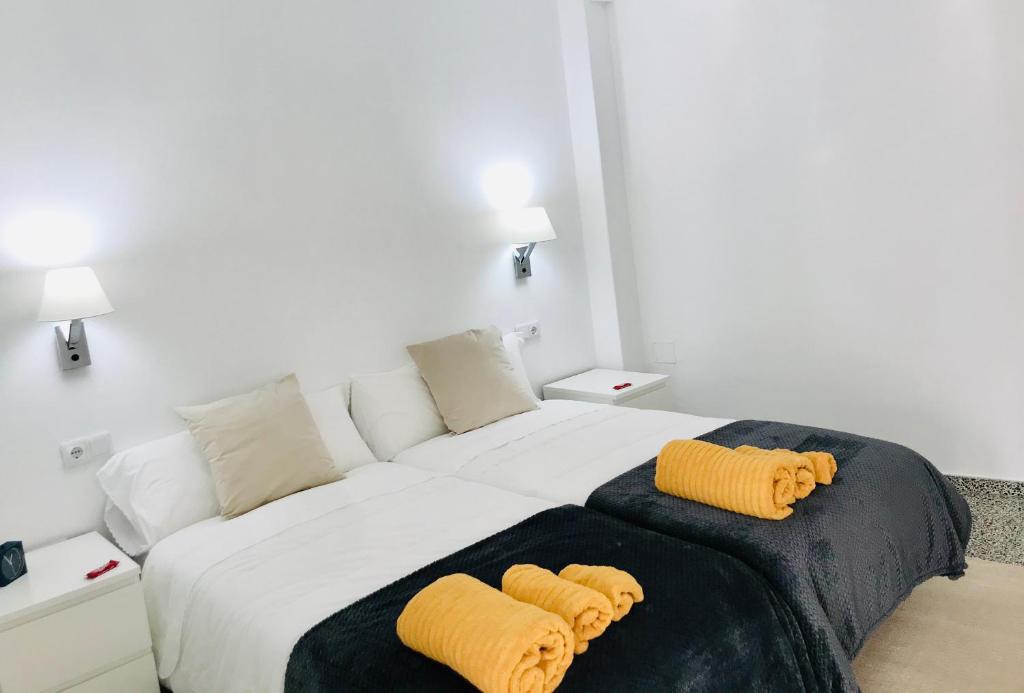 帕德隆Apartamento Padrón Centro, Camino De Santiago P1 UR的一间卧室配有一张大床和两张黄色枕头
