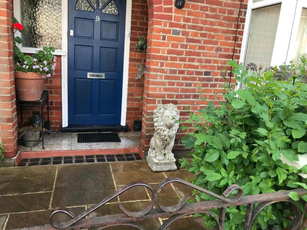 圣奥尔本斯Wynchlands 4 Bedroom House in St Albans City的一座房子前面带狮子雕像的蓝色门