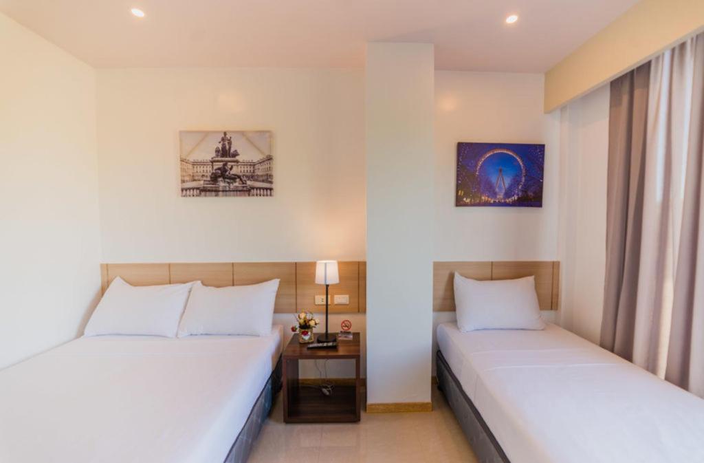 TalibonSoi Suites的一间卧室配有两张床和一张带台灯的桌子
