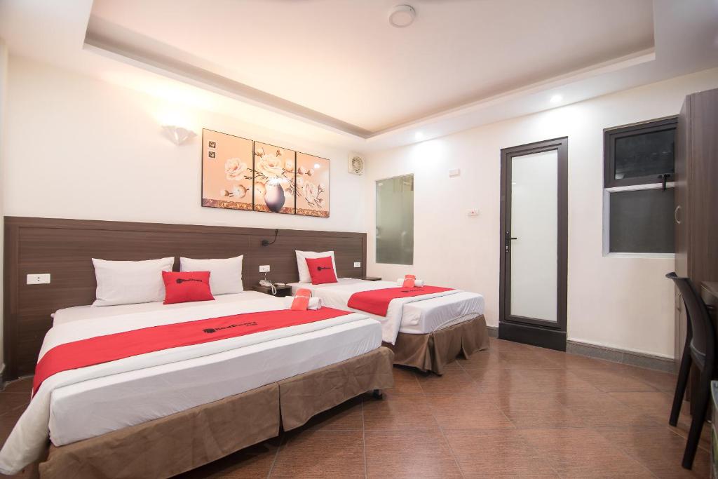 河内Ha Noi Vang Hotel Hoang Ngan的一间卧室配有两张带红色枕头的床
