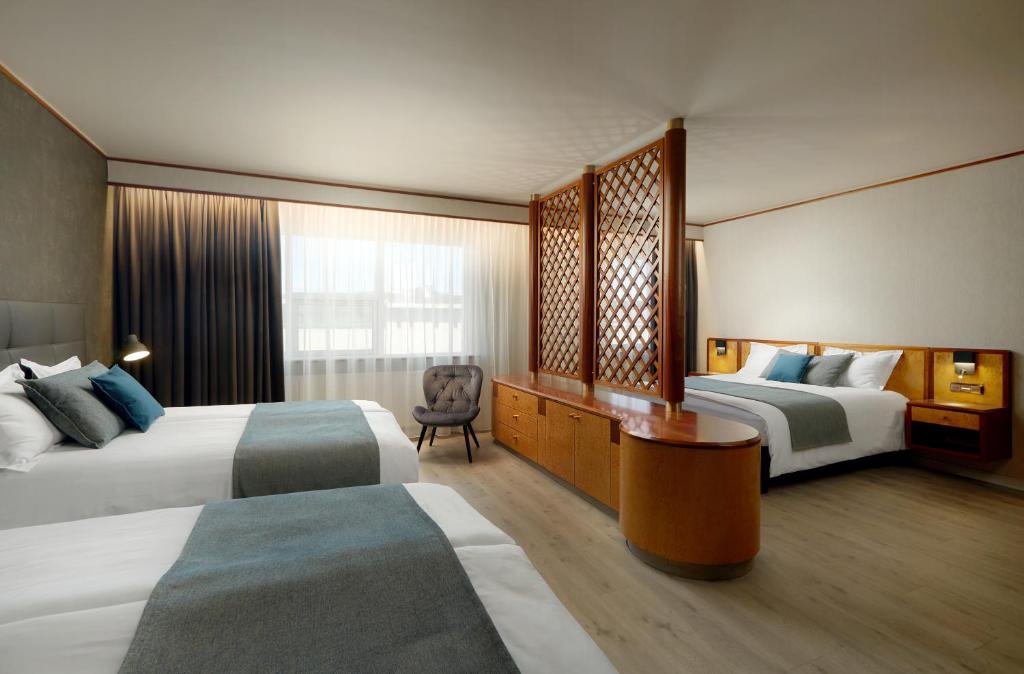 雷克雅未克Hotel Ísland – Spa & Wellness Hotel的酒店客房配有两张床和一张书桌