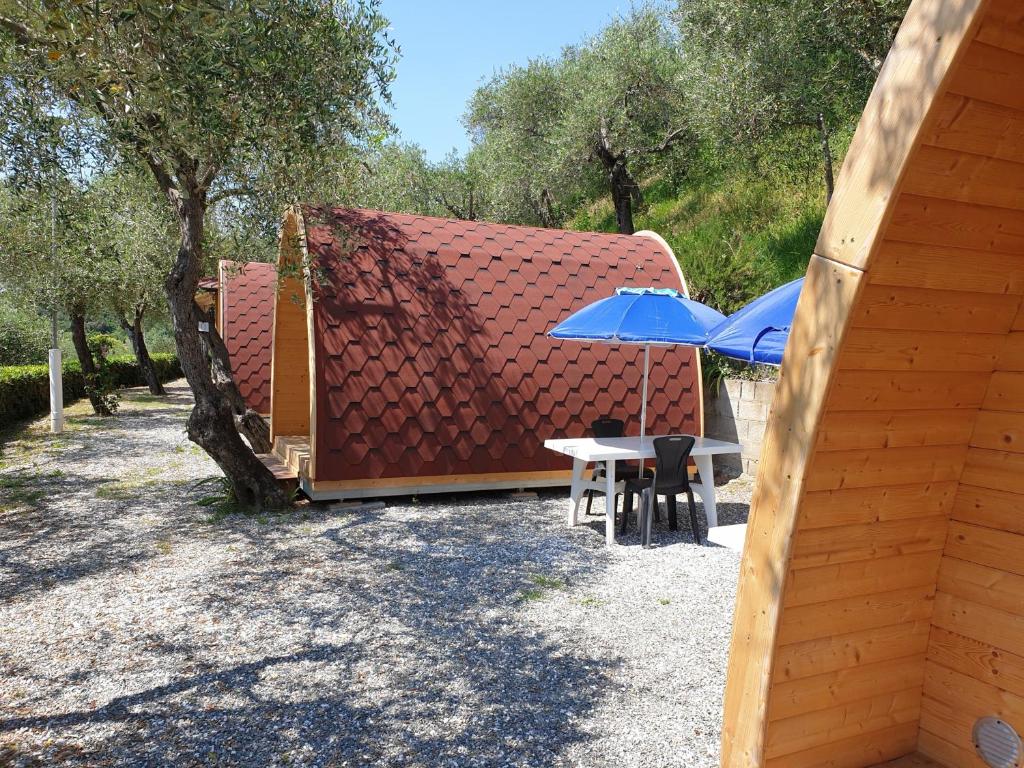 莱里奇Campeggio Gianna Golfo dei Poeti的几张桌子和伞,靠近一座建筑
