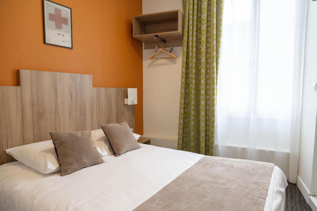 阿姆博斯Logis Hôtel Restaurant Lanex Amboise的卧室配有白色床、橙色墙壁和窗户
