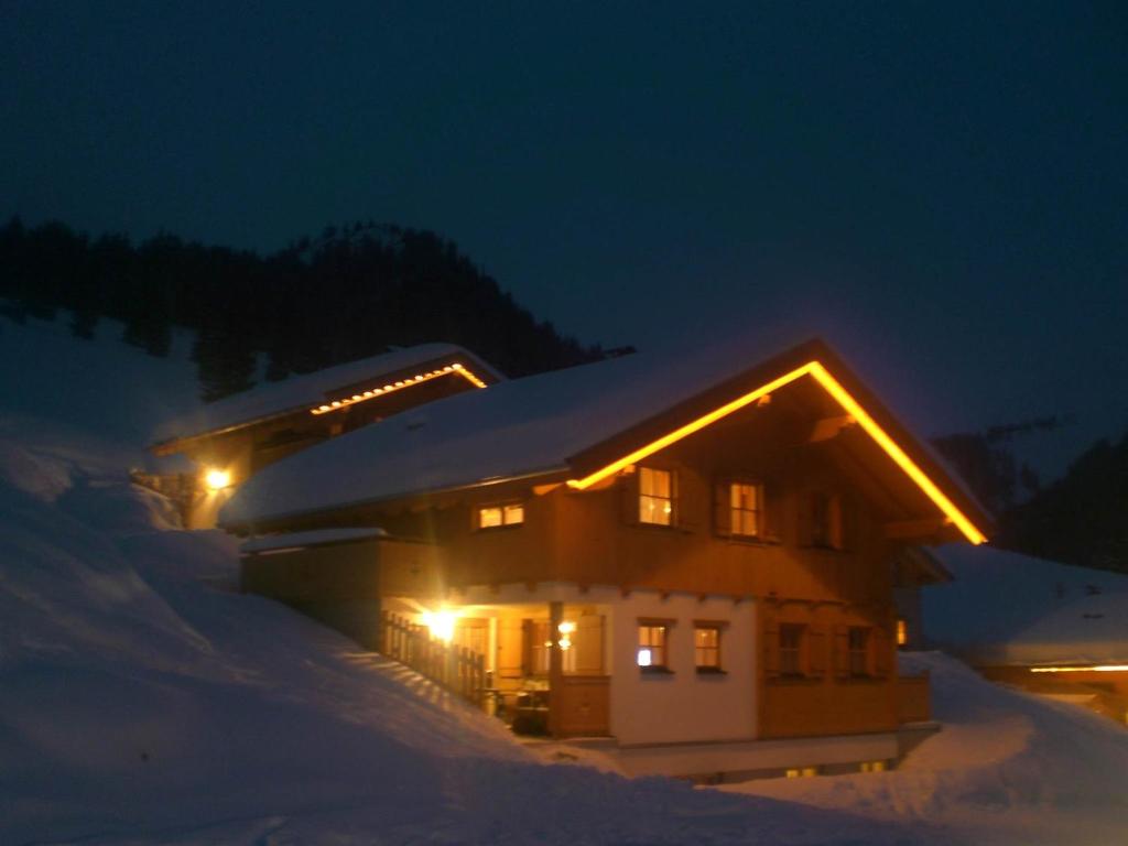 圣加伦基希Dreimäderlhaus的雪覆盖的房屋,晚上有灯