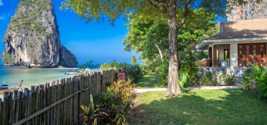 莱利海滩Villa Macaque and Villa Languor的一座有栅栏、树和大海的房子