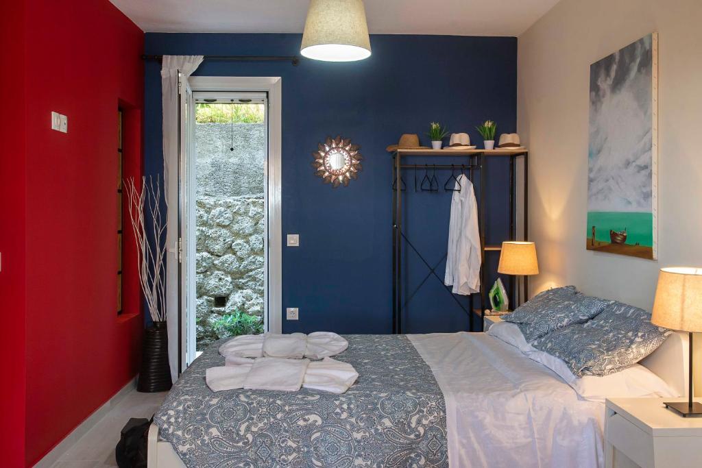 格利法达Ammos Beach House的一间卧室设有一张床和红色及蓝色的墙壁