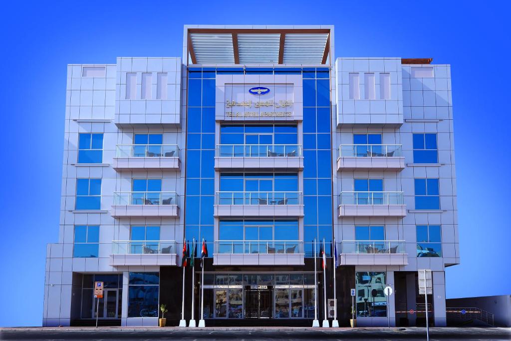 迪拜Telal Hotel Apartments的蓝色的建筑,上面有标志