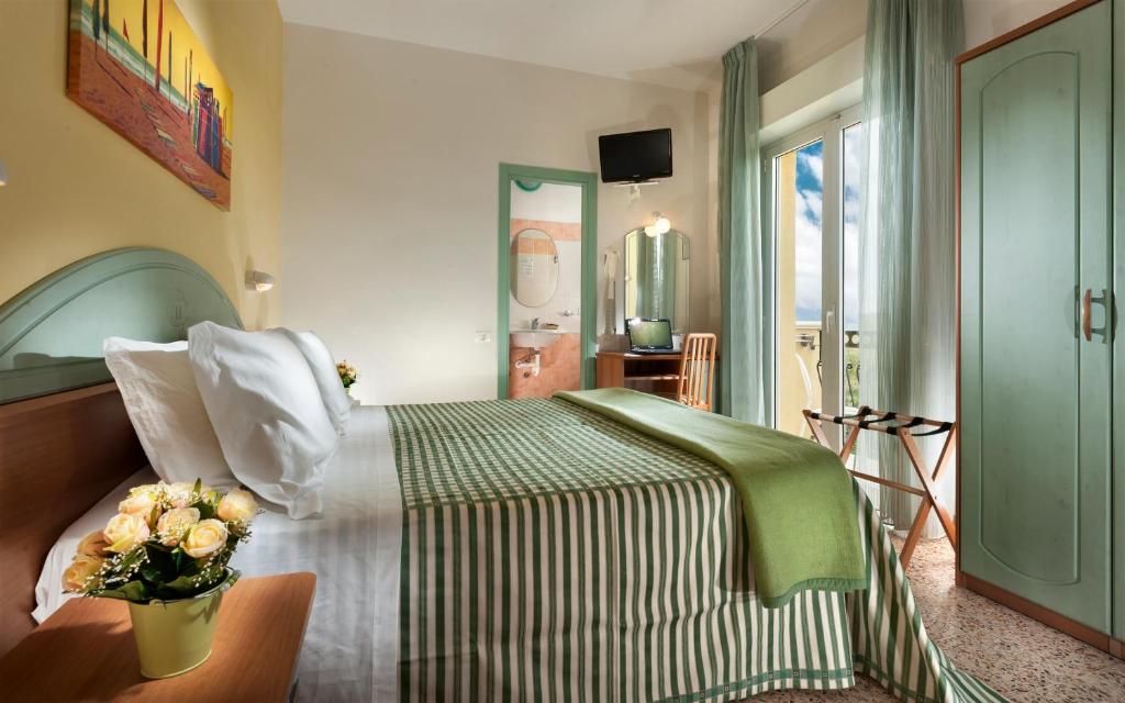 米萨诺阿德里亚蒂科Hotel Caravel B&B的一间卧室,床上放着花瓶