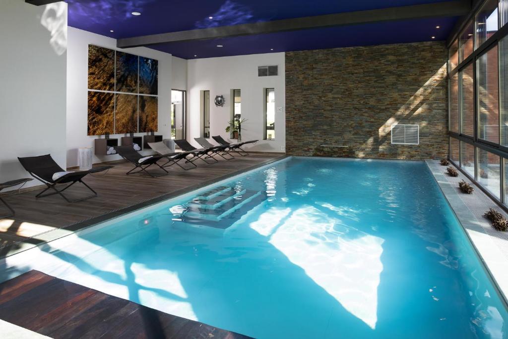 Dracy-le-Fort德拉西温泉酒店的一座带椅子的大型游泳池