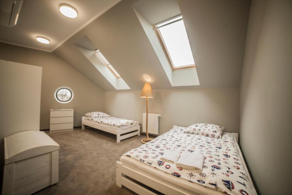 埃尔布隆格Hostel pod Cisem的阁楼卧室设有两张床和天窗
