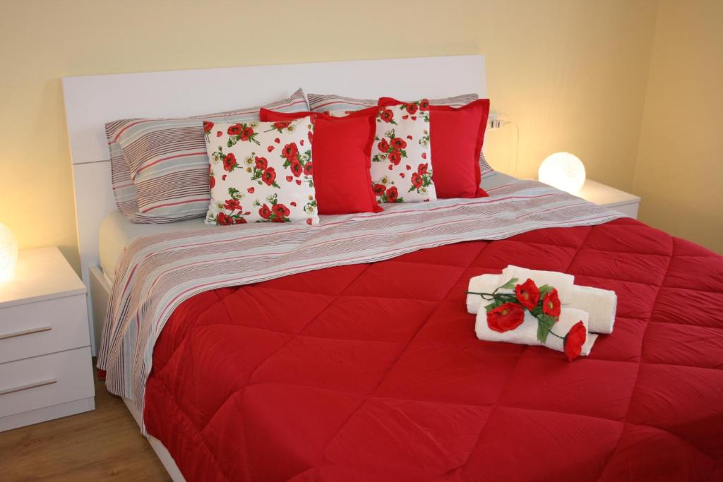 卡尔达诺阿尔坎波Le Margherite的红色的床,上面有红色和白色的枕头
