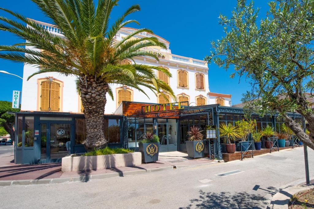 卡里勒鲁埃Hotel Restaurant La Villa Arena的一座建筑前的棕榈树