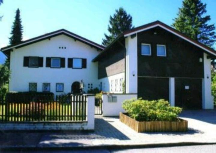 巴特莱辛哈尔Ferienwohnungen Sernatinger的白色和黑色的房子,有黑色的栅栏