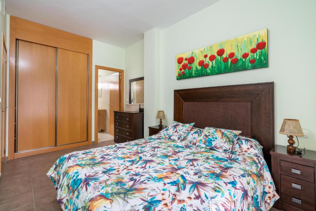 阿尔么丽亚El Rincón de Triana的卧室配有一张床,墙上挂有绘画作品
