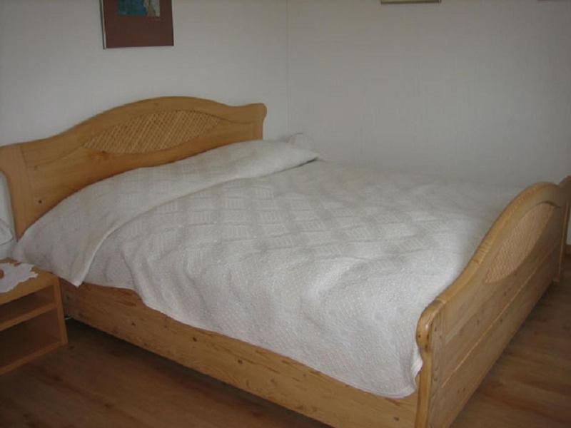 法莱拉Er Liung - Ferienwohnung für max. 3 Personen的一张带白色床单和木桌的木床