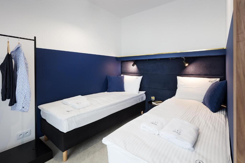 里沃Palicki - Apartamenty z widokiem na morze的蓝色墙壁客房的两张床