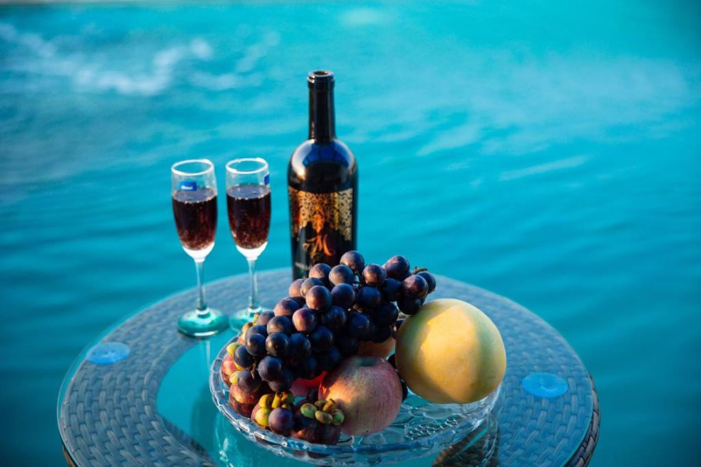 清化Bamboo Hotel的一张桌子,上面放着两杯葡萄酒和一碗水果